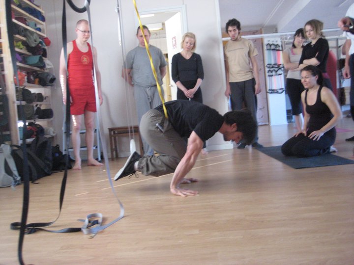 Ido Portal demonstrating how to work on on band-assisted tuck planche.